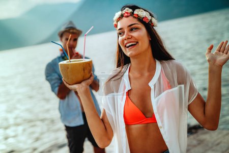 Foto de Felices jóvenes amigos divirtiéndose con cócteles tropicales en la fiesta de playa. Concepto de viajes y vacaciones de verano. - Imagen libre de derechos