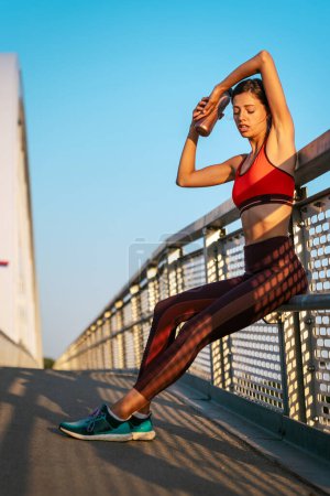 Foto de Retrato de mujer joven en forma y deportiva ejercitándose en la ciudad. Gente deporte ejercicio urbano estilo de vida saludable concepto - Imagen libre de derechos