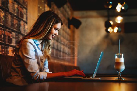 Photo for Happy successful young business woman prepare freelance project working on laptop in cafe - Royalty Free Image