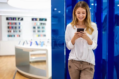 Photo for Happy woman checking social media holding smart phone. Smiling young female using mobile phone app playing game, shopping online, ordering delivery - Royalty Free Image