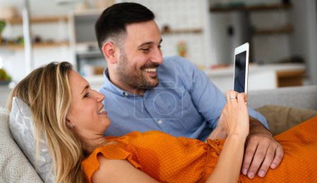 Téléchargez les photos : Portrait of happy young couple with tablet,watching something online. People digital device concept. - en image libre de droit
