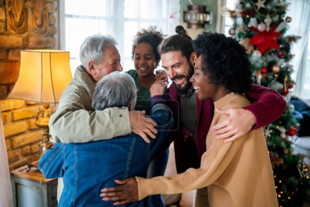 Foto de Feliz alegre familia multiétnica extendida divirtiéndose mientras celebran la Navidad juntos en casa. - Imagen libre de derechos