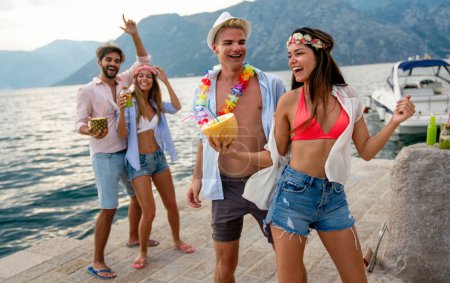 Foto de Grupo multirracial de amigos disfrutando de vacaciones de verano con cócteles. Concepto de amistad, celebración y viaje - Imagen libre de derechos