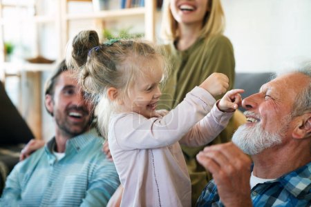 Téléchargez les photos : Joyeux multi-génération famille s'amuser tout en passant du temps ensemble à la maison. Concept de bonheur des gens. - en image libre de droit