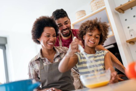 Photo for Happy african american smiling family preparing healthy food in kitchen, having fun together on weekend - Royalty Free Image