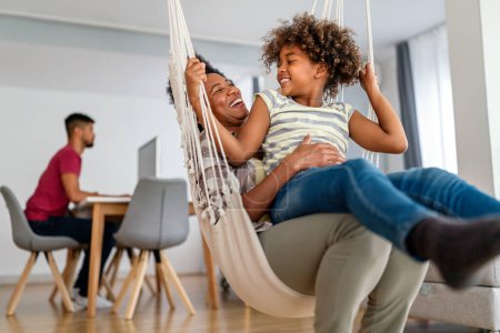 Téléchargez les photos : La mère afro-américaine et sa fille jouent à la maison. Vacances en famille et convivialité. - en image libre de droit