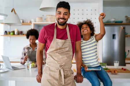Téléchargez les photos : Heureuse famille afro-américaine dans la cuisine s'amuser et cuisiner ensemble. Aliments sains à la maison. - en image libre de droit