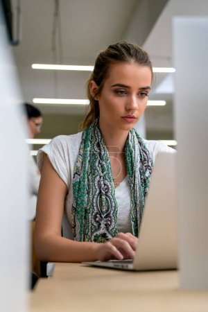 Foto de Retrato de la joven empresaria feliz, estudiante que trabaja con el ordenador portátil sentado en la oficina. - Imagen libre de derechos