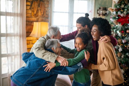 Photo for Excited multiethnic family greeting grandparents on Christmas Day. Multi-generational happy family, holiday concept. - Royalty Free Image