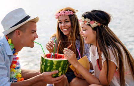 Foto de Grupo de amigos teniendo fiesta hawaiana en vacaciones de verano. Gente diversión viaje mar concepto. - Imagen libre de derechos