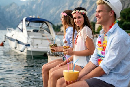 Téléchargez les photos : Groupe d'amis heureux s'amuser avec des cocktails tropicaux sur la fête de la plage. Voyage et vacances d'été concept. - en image libre de droit