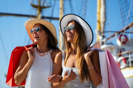 Téléchargez les photos : Plan extérieur de deux jeunes femmes profitant de vacances d'été. Meilleurs amis excités s'amuser et faire du shopping. - en image libre de droit