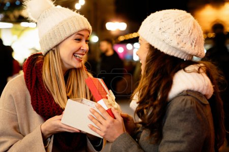 Photo for Portrait of two happy women exchanging christmas presents. Holiday people shopping christmas happiness concept - Royalty Free Image