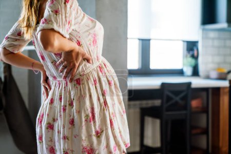 Téléchargez les photos : Femme enceinte ayant des douleurs abdominales et dorsales au cours du dernier trimestre de la grossesse - en image libre de droit