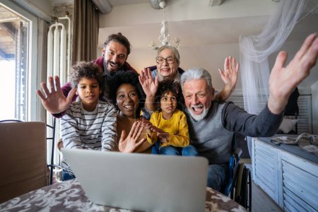 Téléchargez les photos : Joyeux rassemblement familial multigénération autour d'un ordinateur portable et s'amuser lors d'un appel vidéo - en image libre de droit