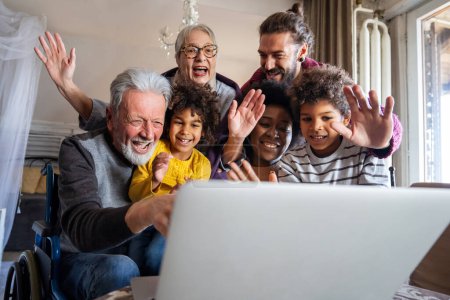 Foto de Feliz multigeneración diversa reunión familiar alrededor de la computadora portátil y divertirse durante una videollamada - Imagen libre de derechos
