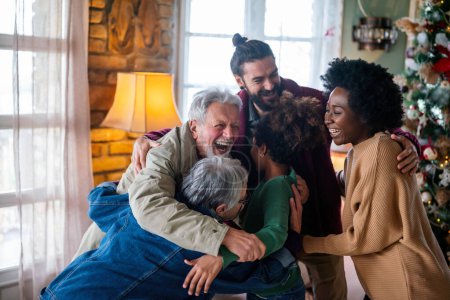 Téléchargez les photos : Heureuse famille multiethnique étendue joyeuse s'amuser tout en célébrant Noël ensemble à la maison. - en image libre de droit