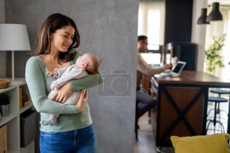 Téléchargez les photos : Mère aimante portant son nouveau-né à la maison. Portrait lumineux de maman heureuse tenant bébé endormi sur les mains. - en image libre de droit