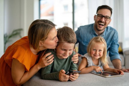 Photo for Happy young family having fun time at home. Parents with children using tablet. People love happiness concept. - Royalty Free Image