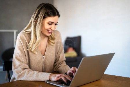 Photo for Home office. One smiling young woman using laptop. Work, freelance, social media, technology concept. - Royalty Free Image