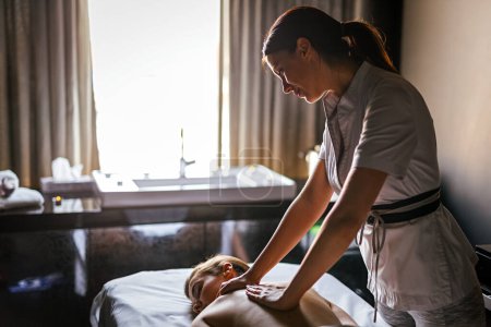 Téléchargez les photos : Jeune femme heureuse caucasienne relaxante avec massage des mains de thérapeute féminine au salon de spa de bien-être beauté - en image libre de droit