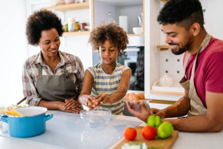 Photo for Happy african american parents and child having fun preparing healthy food in kitchen. Family happiness fun concept - Royalty Free Image