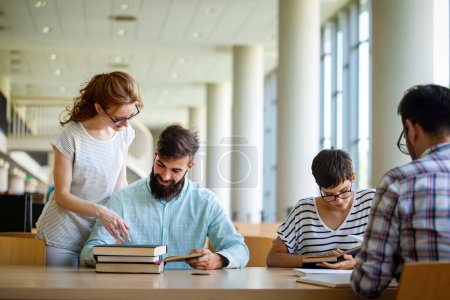 Foto de Los estudiantes están estudiando en la biblioteca. Jóvenes exitosos pasan tiempo juntos y aprenden juntos. - Imagen libre de derechos