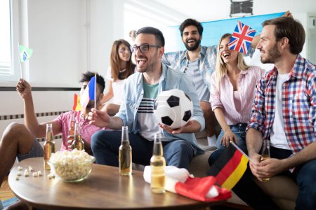 Photo for Young happy group of friends watching sport on television and cheering - Royalty Free Image