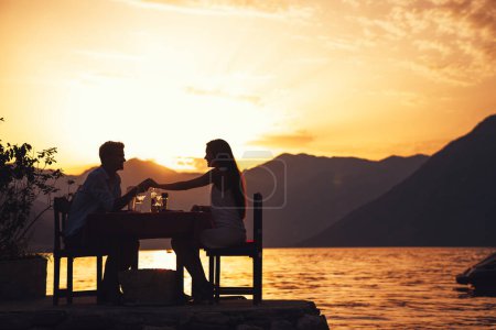 Téléchargez les photos : Couple organise un dîner d'événement privé sur une plage tropicale pendant l'heure du coucher du soleil. Voyage, concept de personnes. - en image libre de droit