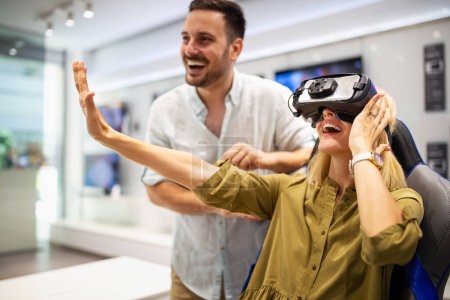 Photo for Couple enjoying with virtual reality headset at tech store. Shopping couple having fun at marketplace. - Royalty Free Image