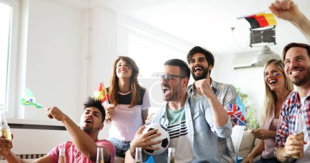 Foto de Grupo de amigos felices divirtiéndose en casa, viendo el partido y disfrutando juntos - Imagen libre de derechos