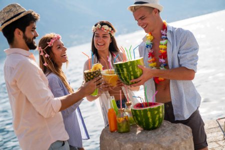 Photo for Group of young friends at the beach drinking cocktails having fun on summer vacation. People travel concept - Royalty Free Image