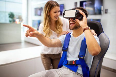 Téléchargez les photos : Couple profiter avec casque de réalité virtuelle au magasin de technologie. Couple shopping s'amuser au marché. - en image libre de droit