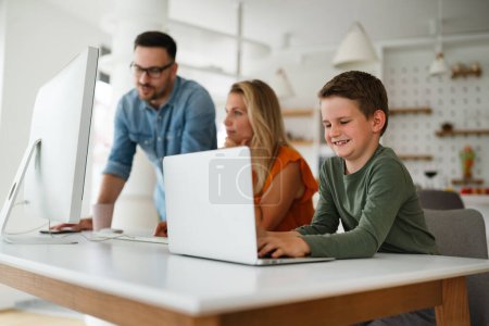Photo for Working from home with child. Busy young business parents working while kid playing on laptop. - Royalty Free Image