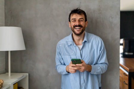 Foto de Hombre feliz usando teléfono inteligente, chat de mensajería en línea en el móvil. Gente tecnología concepto de medios sociales. - Imagen libre de derechos