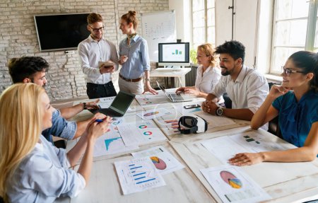 Diverse businesspeople discuss financial report in charts diagrams and graphs, business partners analyzing common sales statistics presenting deal benefits at group meeting concept