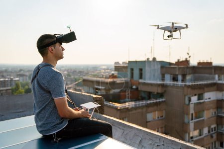 Téléchargez les photos : Homme opérant un drone avec télécommande extérieure - en image libre de droit