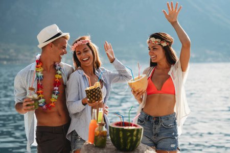 Foto de Grupo de amigos multiétnicos disfrutando de la fiesta hawaiana en vacaciones de verano. Vibraciones veraniegas, concepto de viaje. - Imagen libre de derechos