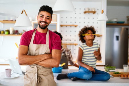 Photo for Overjoyed young african american family with preteen kid have fun in kitchen at home together, happy smiling parents enjoy weekend play with child - Royalty Free Image