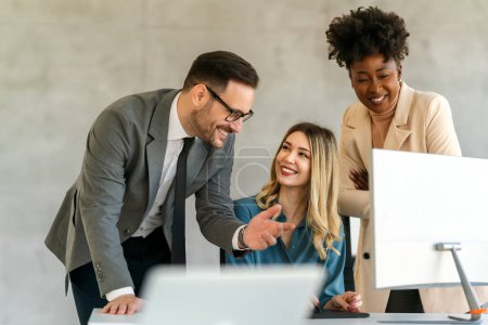 Photo for Business professionals. Group of multiethnic business people analyzing data using computer while working as a team in the office - Royalty Free Image