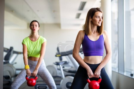 Photo for Beautiful happy fit women, friends exercising, working out in gym together. Sport people health concept - Royalty Free Image