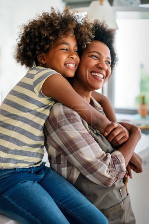 Téléchargez les photos : Femme afro-américaine étreignant sa fille adolescente heureuse et souriante. Amour familial concept d'enfant monoparental - en image libre de droit