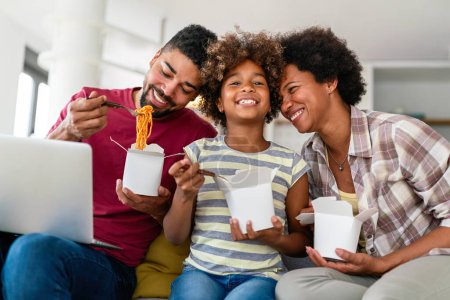 Photo for Family home delivary takeaway food concept. Happy african american family eating at living room and enjoying time together. - Royalty Free Image