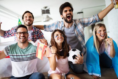 Photo for Excited and happy fans of soccer friends celebrating winning match at home - Royalty Free Image