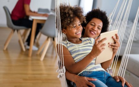 Photo for African american mother and preteen daughter watching entertainment on digital tablet at home - Royalty Free Image