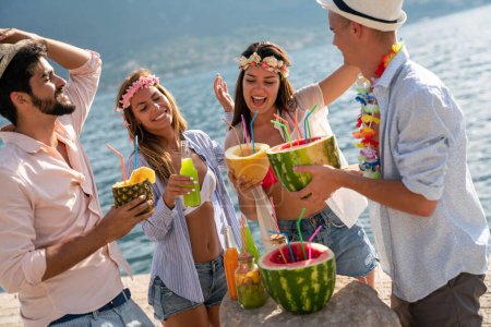Foto de Grupo de amigos teniendo fiesta hawaiana en vacaciones de verano. Gente diversión viaje mar concepto. - Imagen libre de derechos