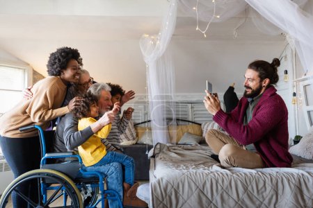 Photo for Happy big multiethnic diverse family enjoying weekend together at home. Senior people with wheelchair. - Royalty Free Image