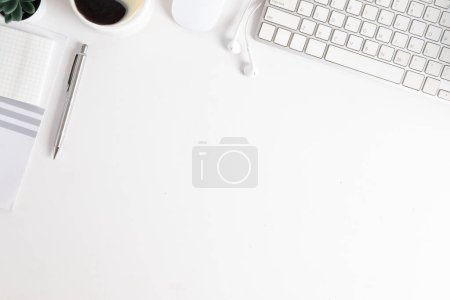 Foto de Escritorio blanco de vista superior con taza de café, teclado, portátil y auriculares. Copia espacio para tu texto. - Imagen libre de derechos