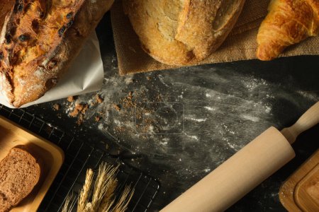 Téléchargez les photos : Vue ci-dessus de l'assortiment pain maison, blé et rouleau à pâtisserie en bois sur table rustique. - en image libre de droit