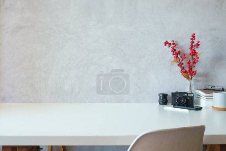 Foto de Escritorio de la oficina con libros de cámara, taza de café y teléfono inteligente en la mesa blanca. Copia espacio para tu texto. - Imagen libre de derechos